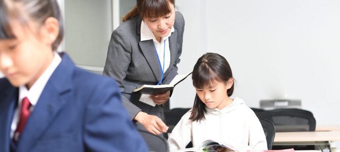 授業中に勉強をする女子学生と塾講師のイメージ